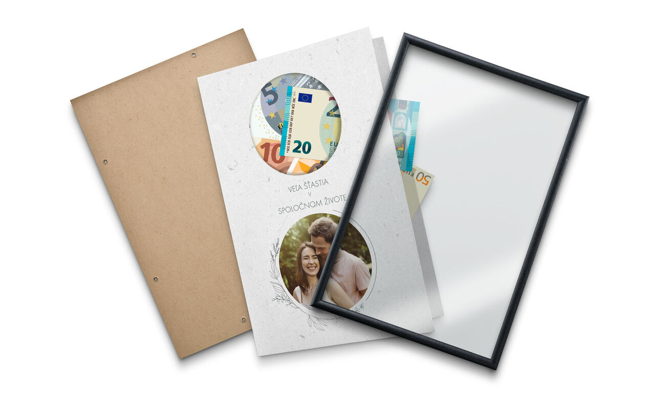 CEWE fotokniha s dvoma kruhovými obrázkami a bankovkami umiestnená na stole