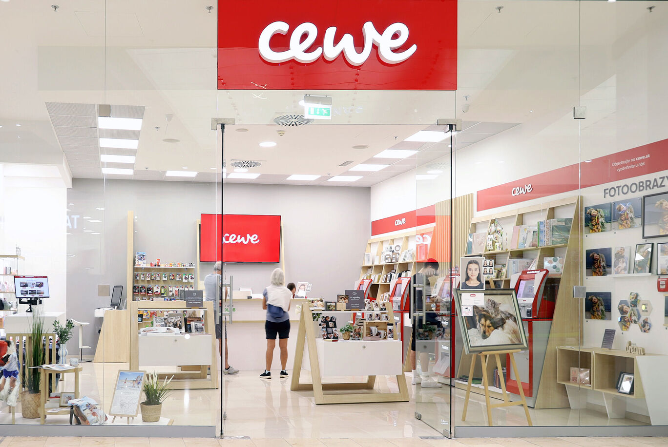 Svetlá predajňa CEWE s priateľskou atmosférou a rôznymi fotoproduktmi.