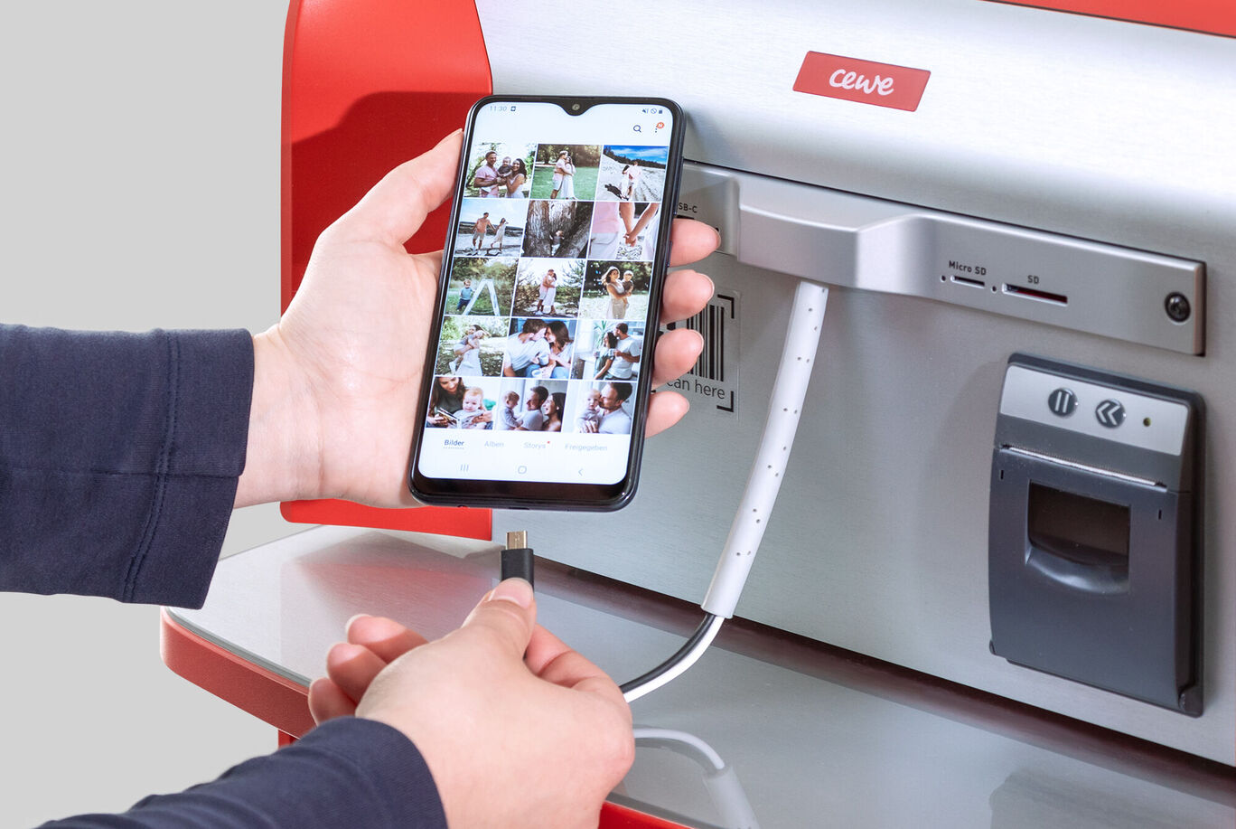 Osoba pripája smartphone k CEWE fototlačiarni.