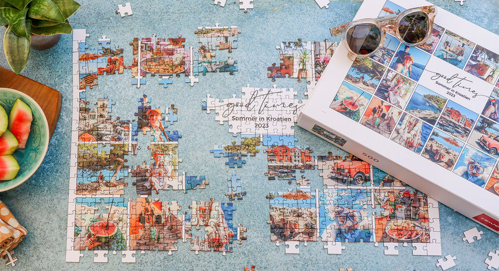 Puzzle s obrázkami Chorvátska na stole, vedľa je krabica a slnečné okuliare. Úžasné dovolenkové spomienky