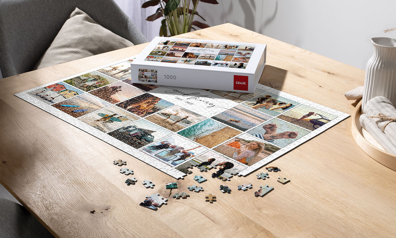 Puzzle s 1000 dielikmi a mnohými obrázkami na drevenom stole, niektoré dieliky ležia vedľa
