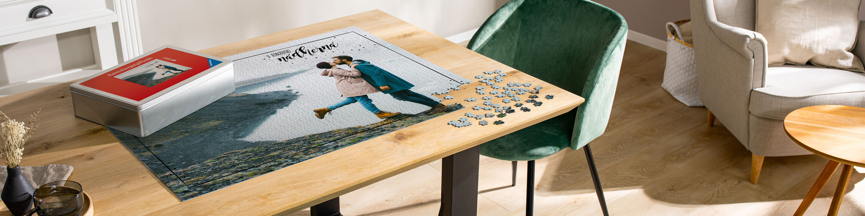 Šťastný pár si prezerá CEWE fotoknihu pri stole. Na stole je puzzle a šálka kávy.