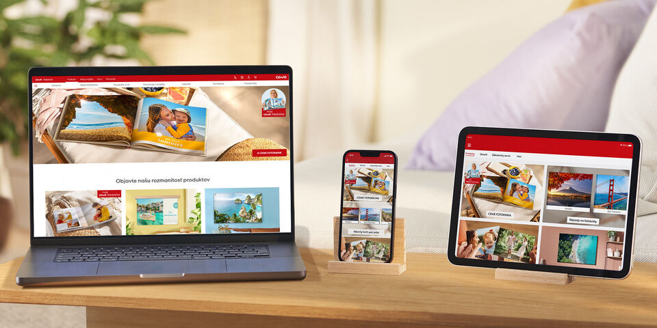 Rodina si pozerá CEWE Fotoknihu na notebooku, mobile a tablete.