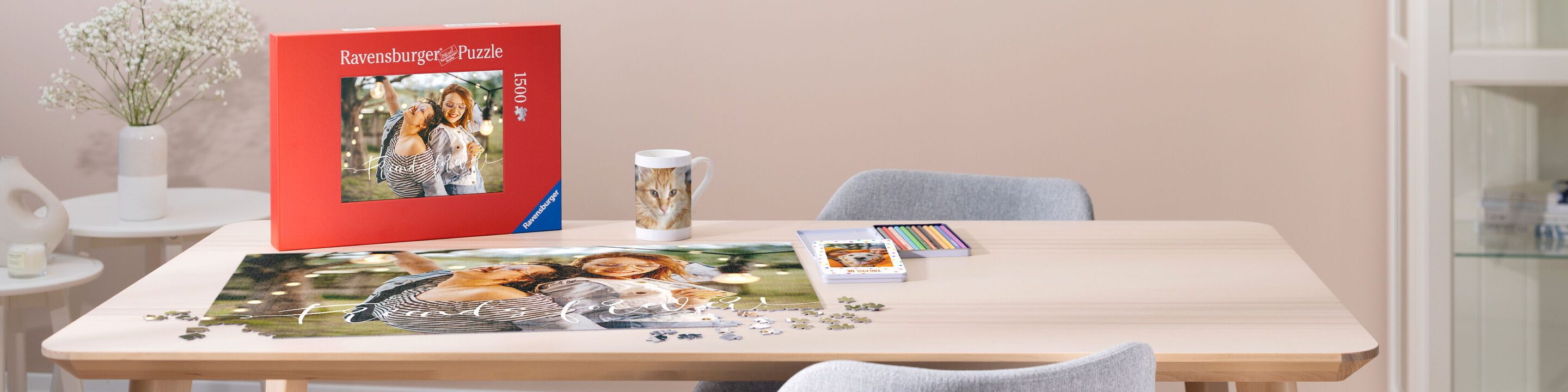 Stôl s puzzle a produktami CEWE. Na stole ležia CEWE Fotokniha, hrnček a puzzle povrch s obrázkom dvoch osôb.