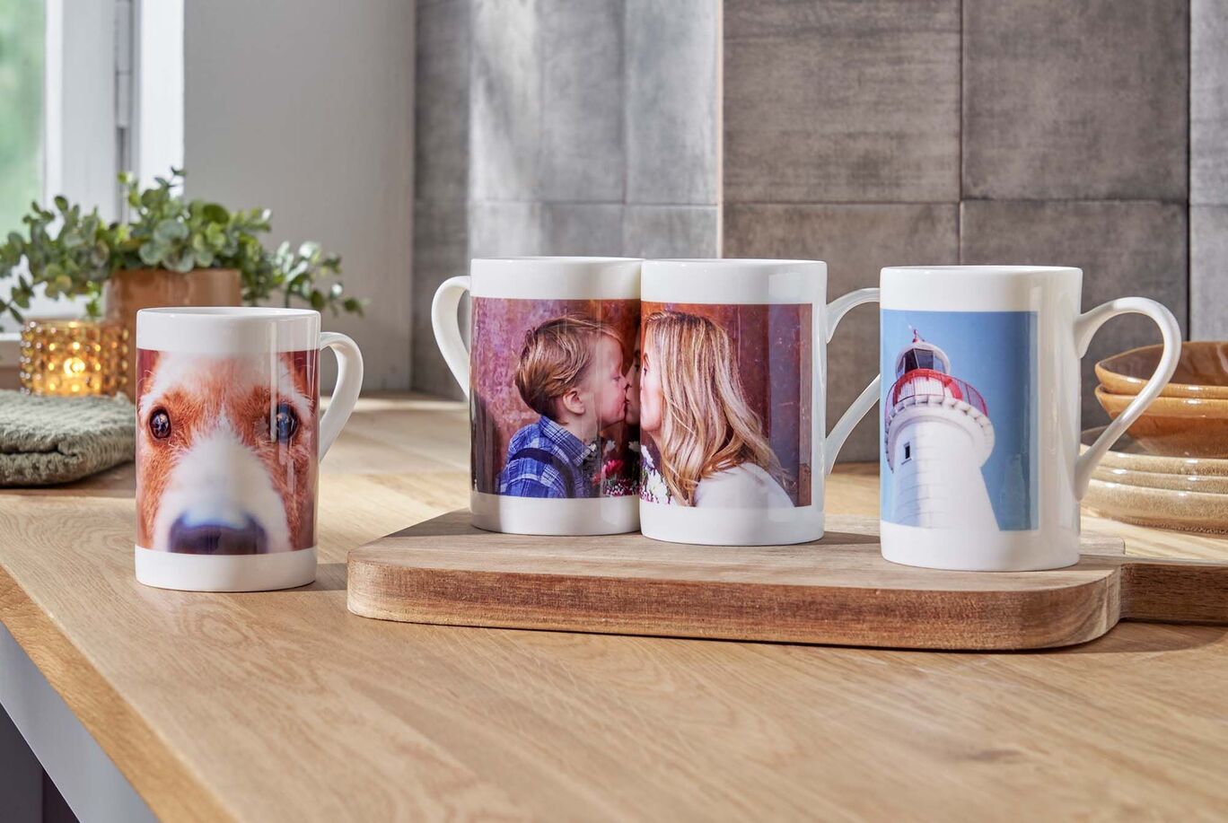 Osoby držia personalizované šálky s fotkami v útulnej kuchyni.