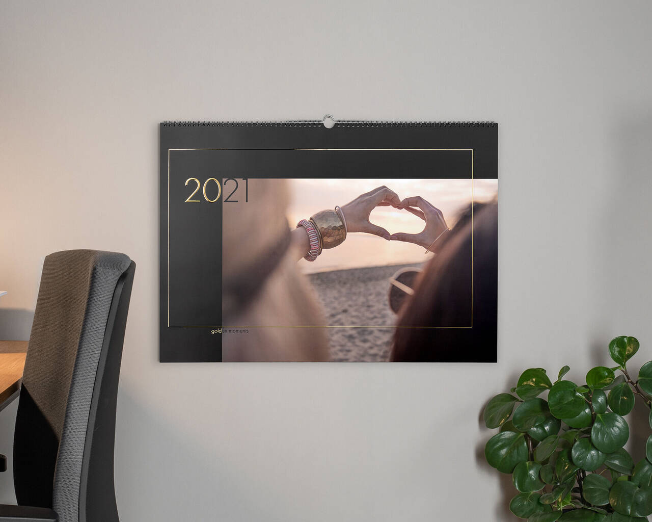 Dve ruky tvoria tvar srdca pred nástenným kalendárom 2021.