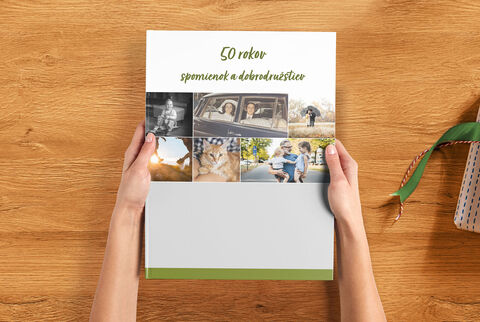 Osoba drží CEWE FOTOKNIHU s fotografiami výnimočných spomienok.