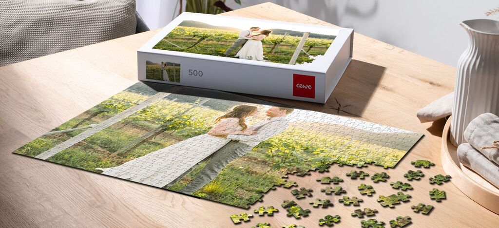 Láskyplný pár v lúke obklopený puzzlami, v pozadí puzzle box od CEWE