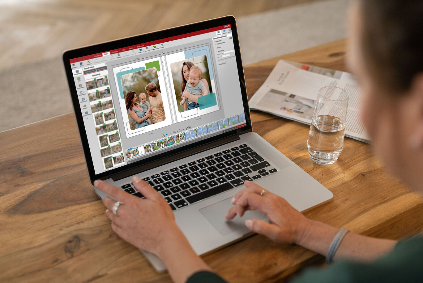 Osoba navrhuje CEWE Fotoknihu na notebooku. Prezera si fotky a upravuje rozloženie.