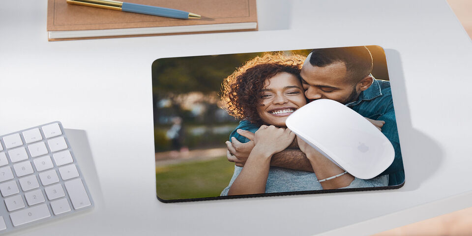 Milujúci pár sa srdečne objíma, obkolesený prírodou.