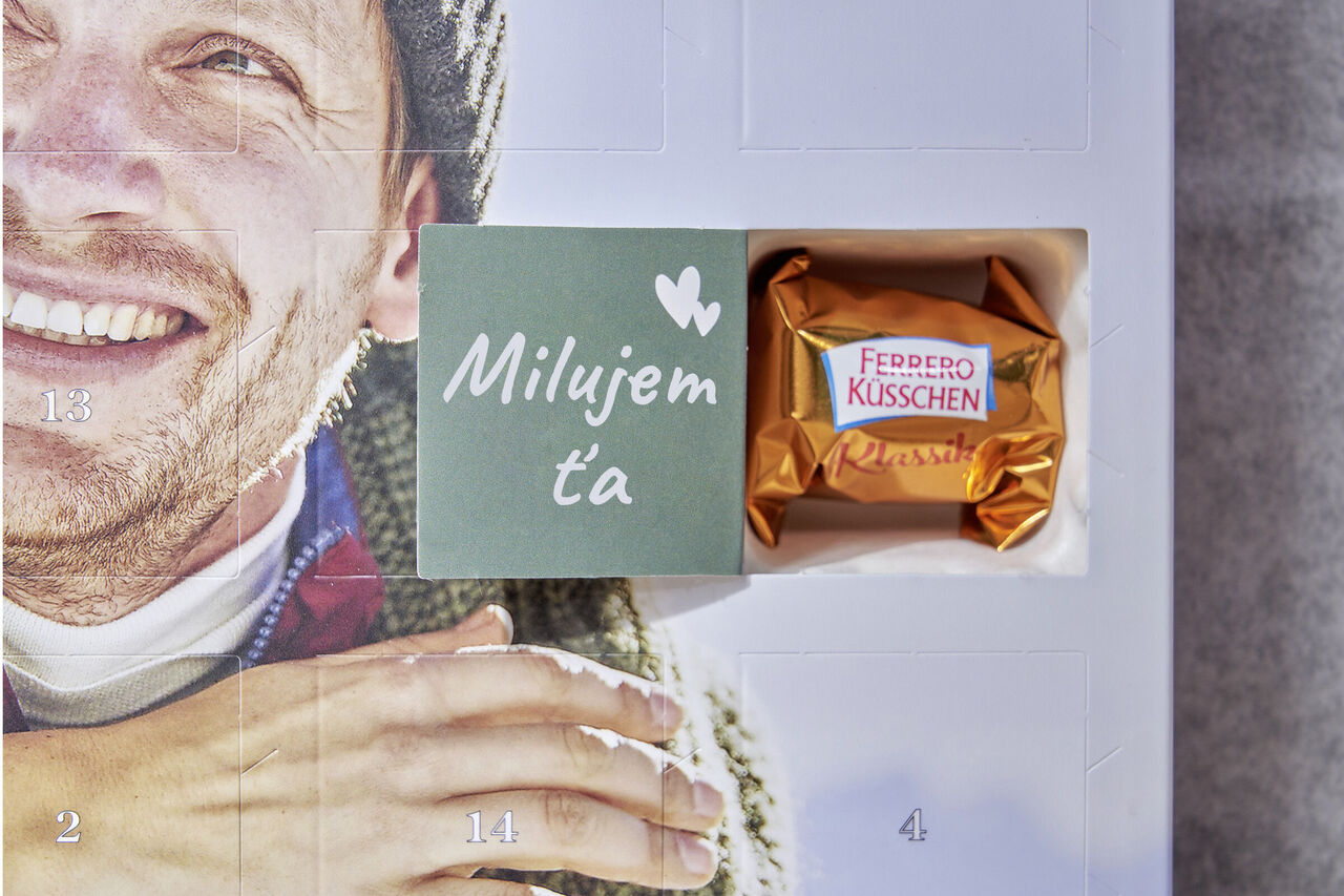 Adventný kalendár so zlatou čokoládou Ferrero Kusschen a malou kartou s textom 'Milujem ťa'.