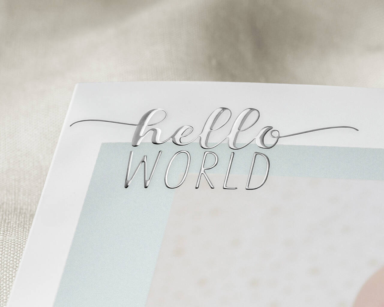 Vizitka s nápisom 'hello WORLD' na svetlom pozadí.