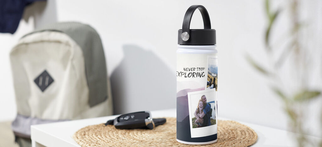 Osoba sedí na podložke a drží personalizovanú fľašu s fotografiami počas pikniku.