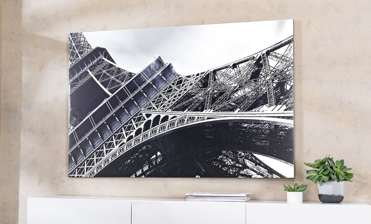 Čiernobiela fotografia Eiffelovej veže v Paríži, pohľad zdola na štruktúru.