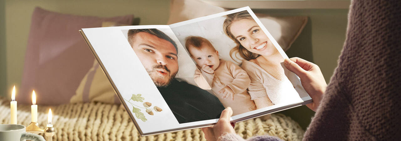 Láskyplná fotokniha so spomienkami, ktorú drží osoba v útulnej miestnosti.