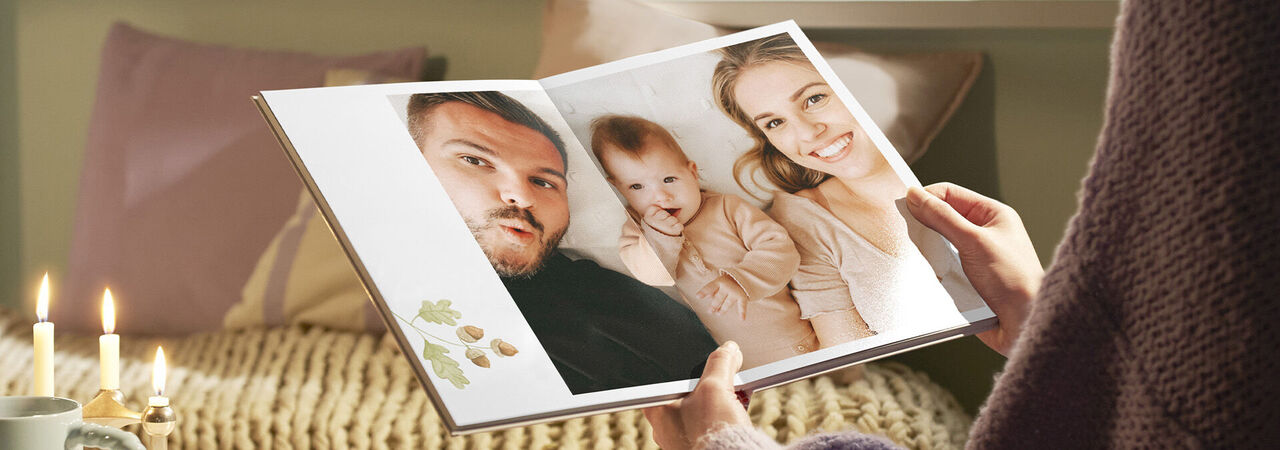 Láskyplná fotokniha so spomienkami, ktorú drží osoba v útulnej miestnosti.