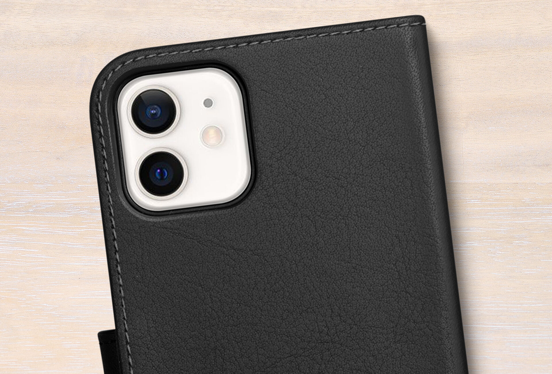 Čierny ochranný kryt pre iPhone 12 na svetlom podklade, zobrazuje kamerové moduly zariadenia.