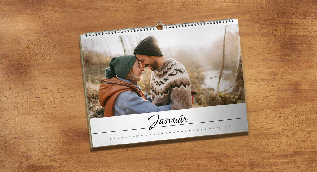Pár si láskyplne objíma pri zimnej krajine v kalendári.