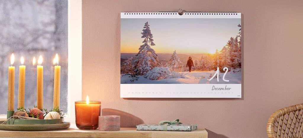 Krásny kalendár na december so západom slnka a zasneženými stromami.