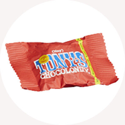 Červený bonbón od Tony's Chocolonely so žltou nálepkou.