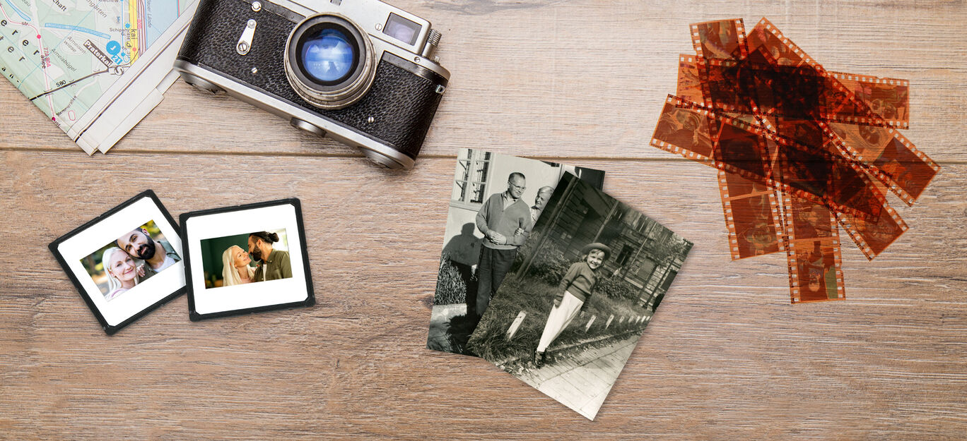 Starý fotoaparát, fotografie a negatívy na stole, ktoré pripomínajú minulé výlety.