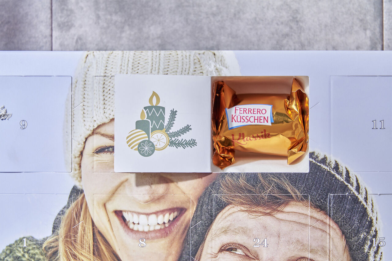 Láskavo navrhnutá adventná stránka s Ferrero Küsschen zabaleným v zlatej fólii.