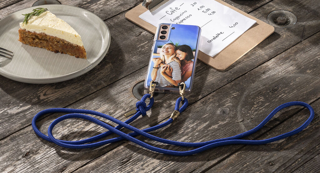 Osoby na obale smartfónu v kaviarni s koláčom a objednávkovým lístkom