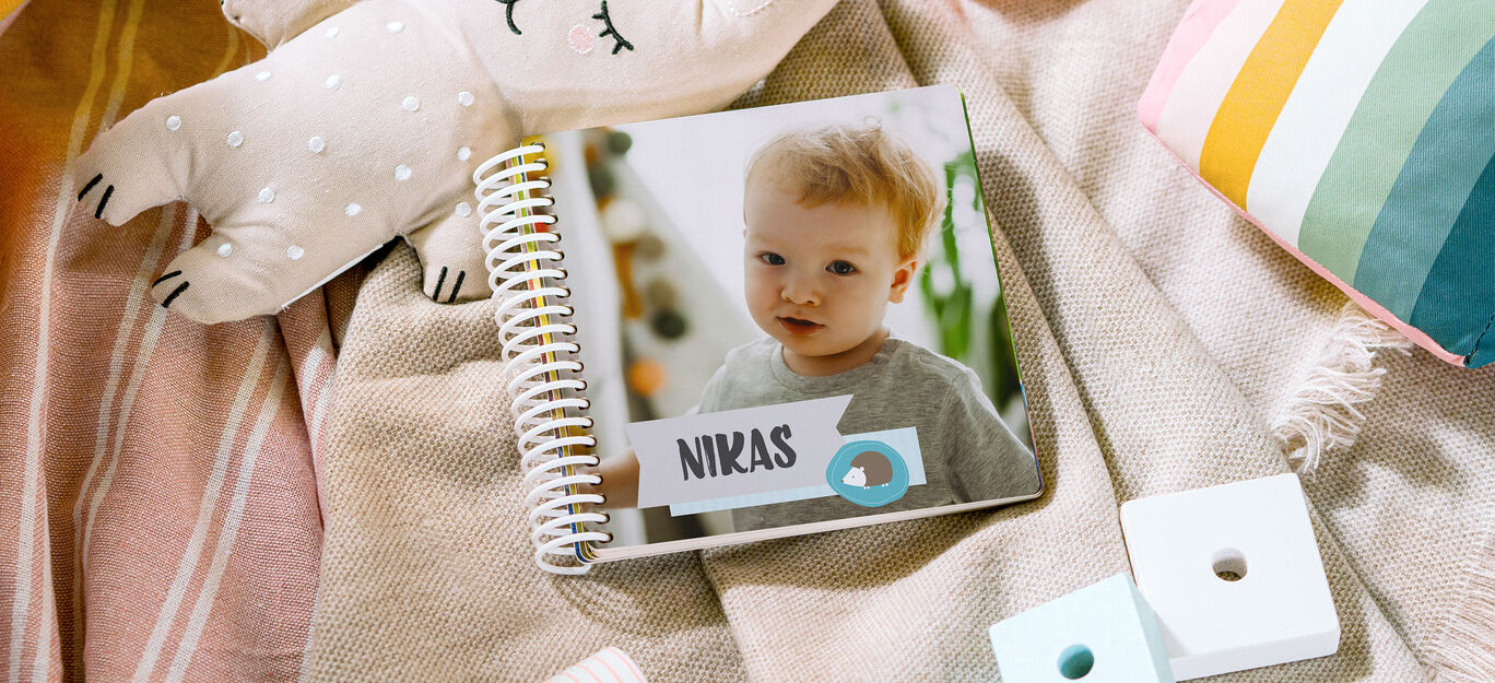 Jedinečná fotokniha pre deti na deke. Ukazuje šťastné dieťa s jedinečným menom.