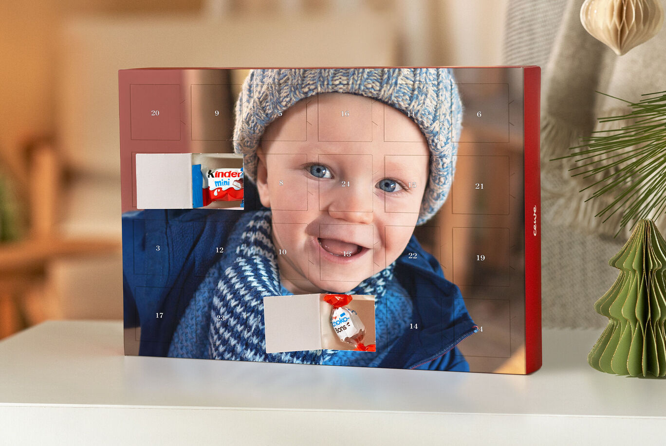 Adventný kalendár s fotkami čokolád a dieťaťa v modrom kabáte na dojemnom pozadí.