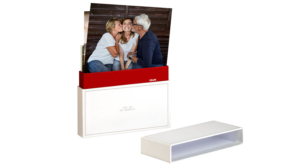 Fotokniha CEWE s elegantným dizajnom zachytáva jasné spomienky. Obal ukazuje šťastné osoby pri stretnutí.