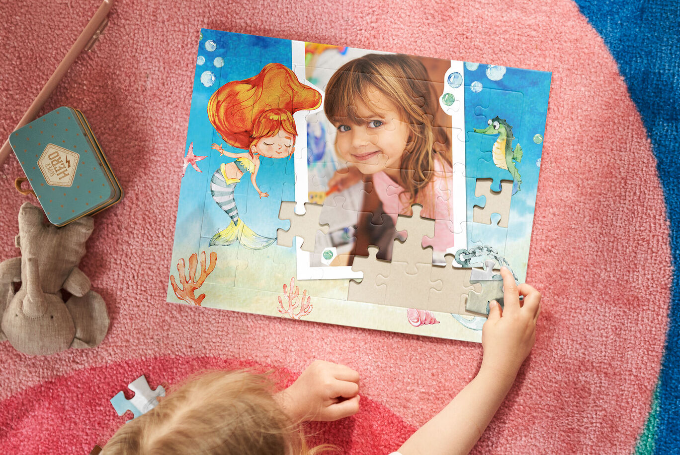 Dieťa skladá puzzle s morským motívom so šachovnicou a farebnými rybami.
