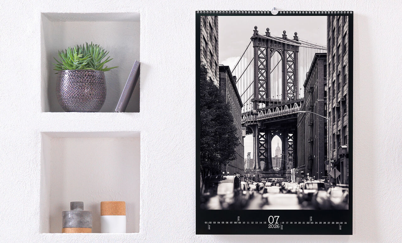 Kalendár s čiernobielou fotografiou Brooklyn Bridge, zdobený rastlinami.