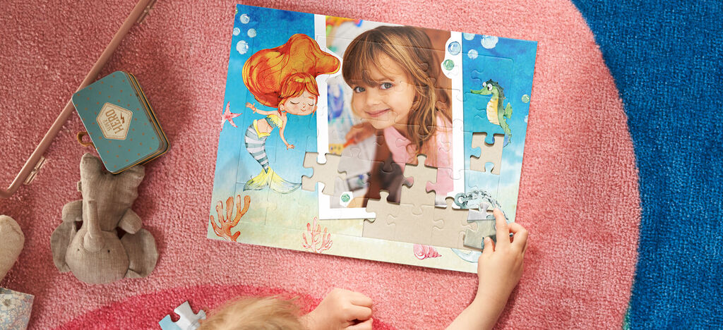 Dieťa skladá pestrú puzzle o podmorskom svete.