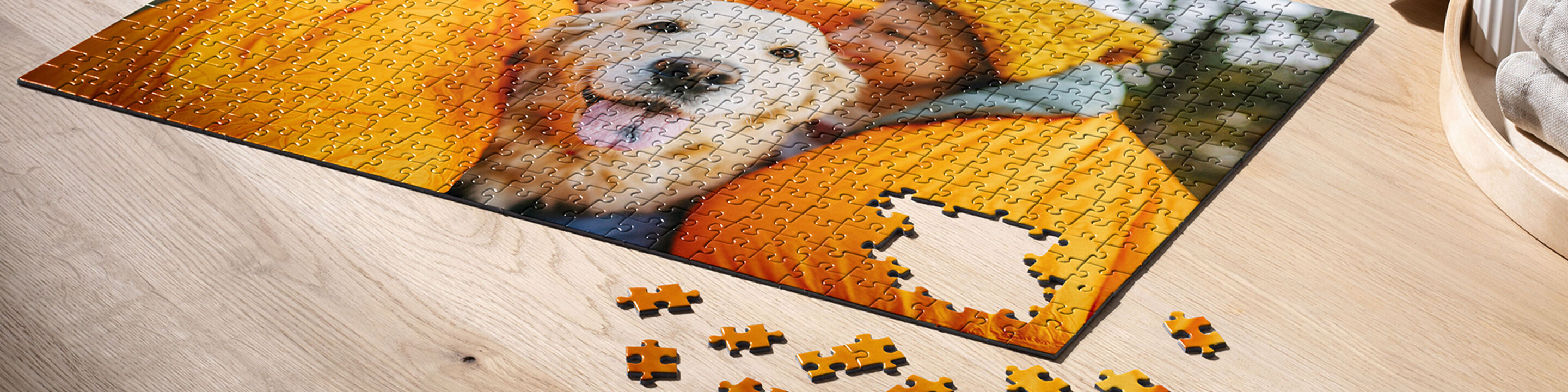 Takmer dokončené puzzle so šťastným psíkom a osobou v žltom kabáte na stole