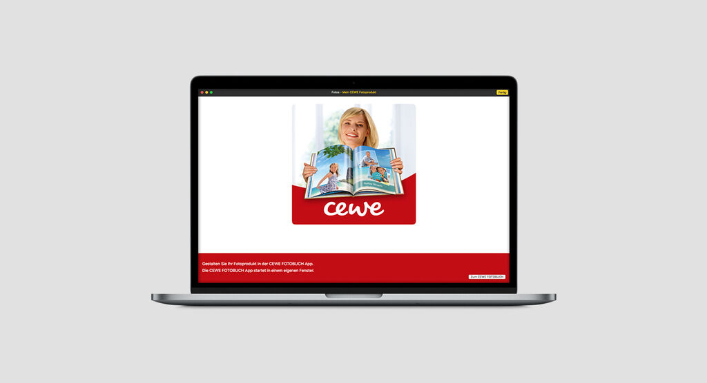 Osoba si prezerá CEWE FOTOKNIHU na notebooku.