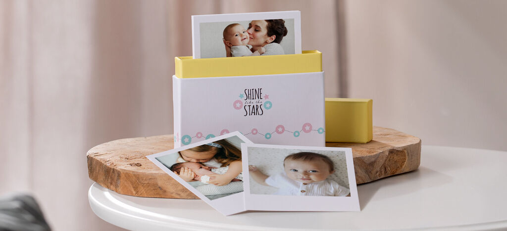 Mini fotokniha s fotografiami bábätka na stole