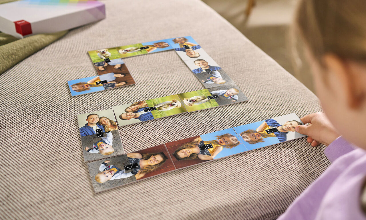 Dieťa sa hrá s fotopuzzle, ktoré zobrazuje rôzne osobné fotografie.