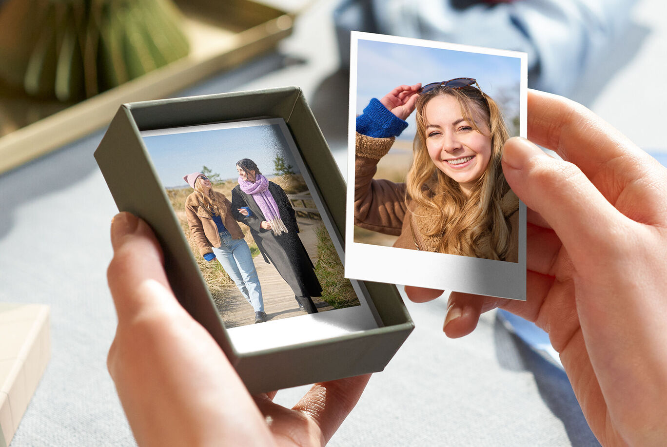 Osoba drží darček s dvoma fotografiami, na ktorých sú šťastné chvíle.