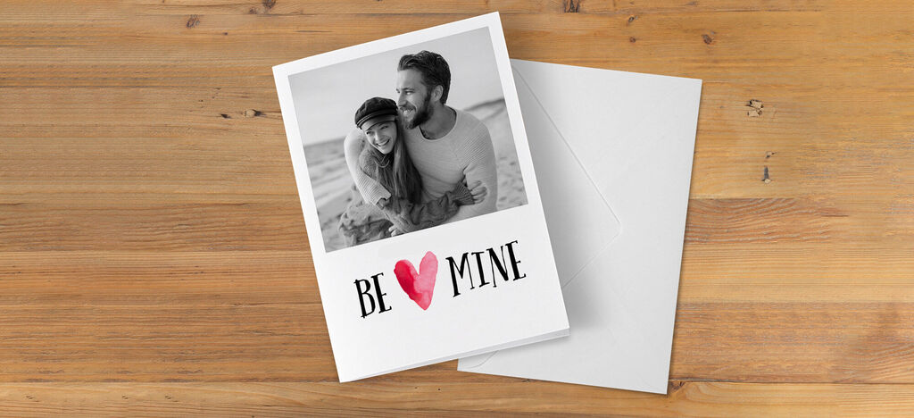 Láskavá romantická pohľadnica s motívom a nápisom 'BE MINE'.