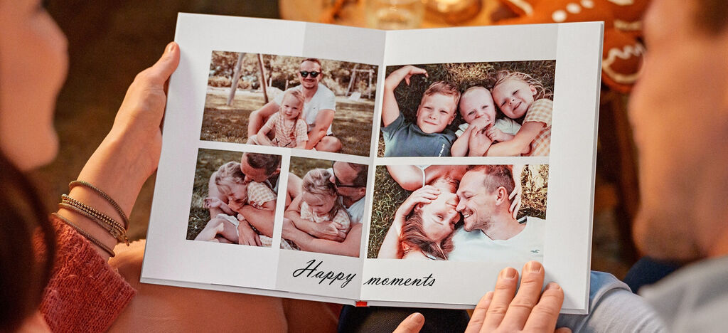 Pár drží CEWE fotoknihu so šťastnými spomienkami v rukách