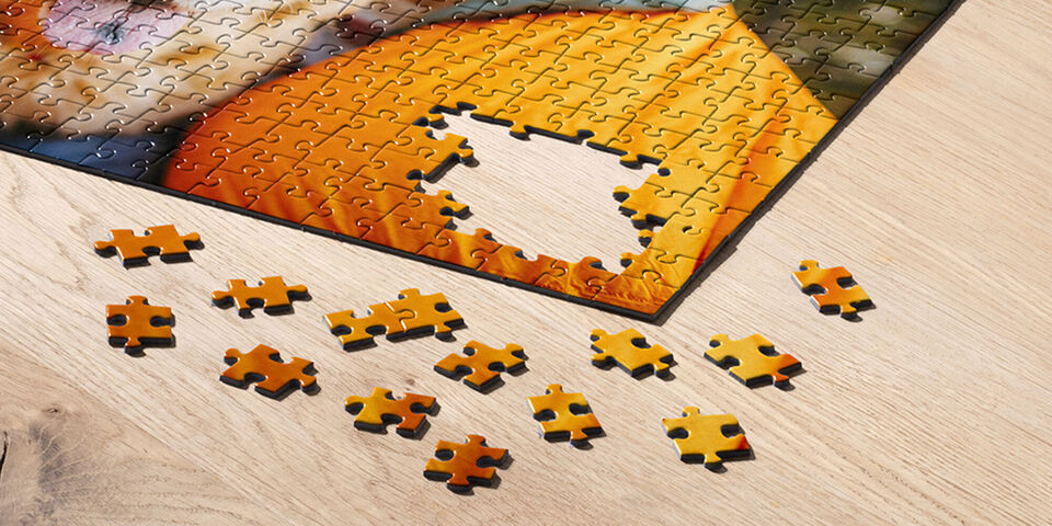 Takmer dokončené puzzle s jedným chýbajúcim kúskom na stole.