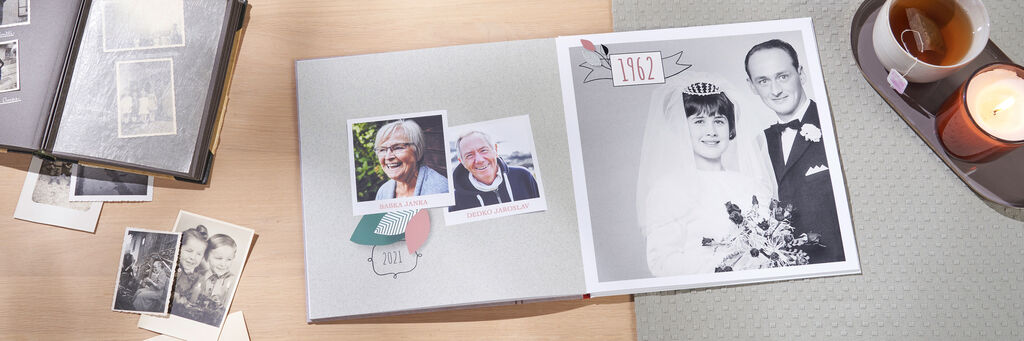 Otvorená fotokniha so svadobnými fotografiami a láskyplnými spomienkami. Vedľa stojí sviečka.