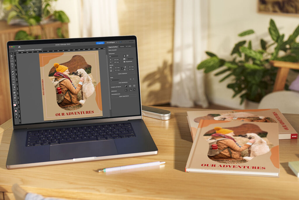 Notebook zobrazuje kreatívny dizajn s fotografiou dobrodružstiev, vedľa sú fotoknihy CEWE.