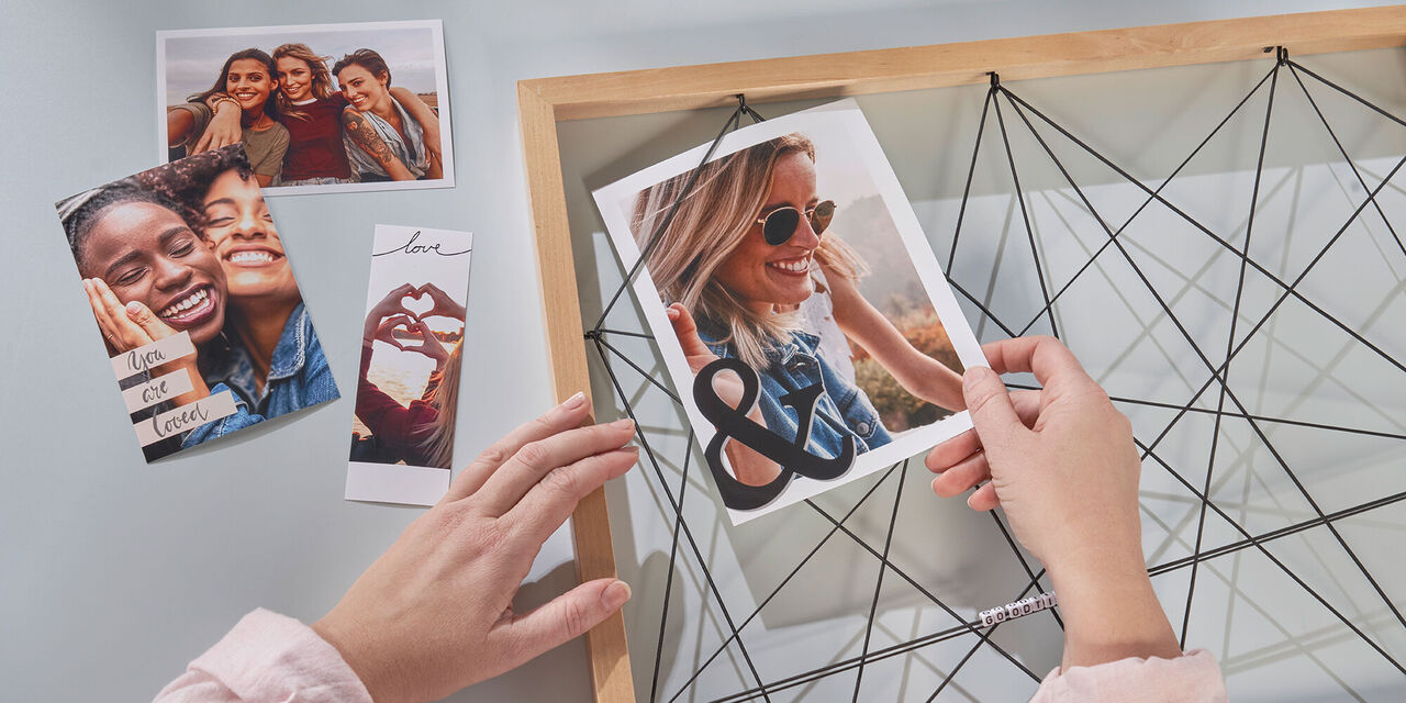 Ruky upevňujú fotografiu do rámu na zdieľanie spomienok.