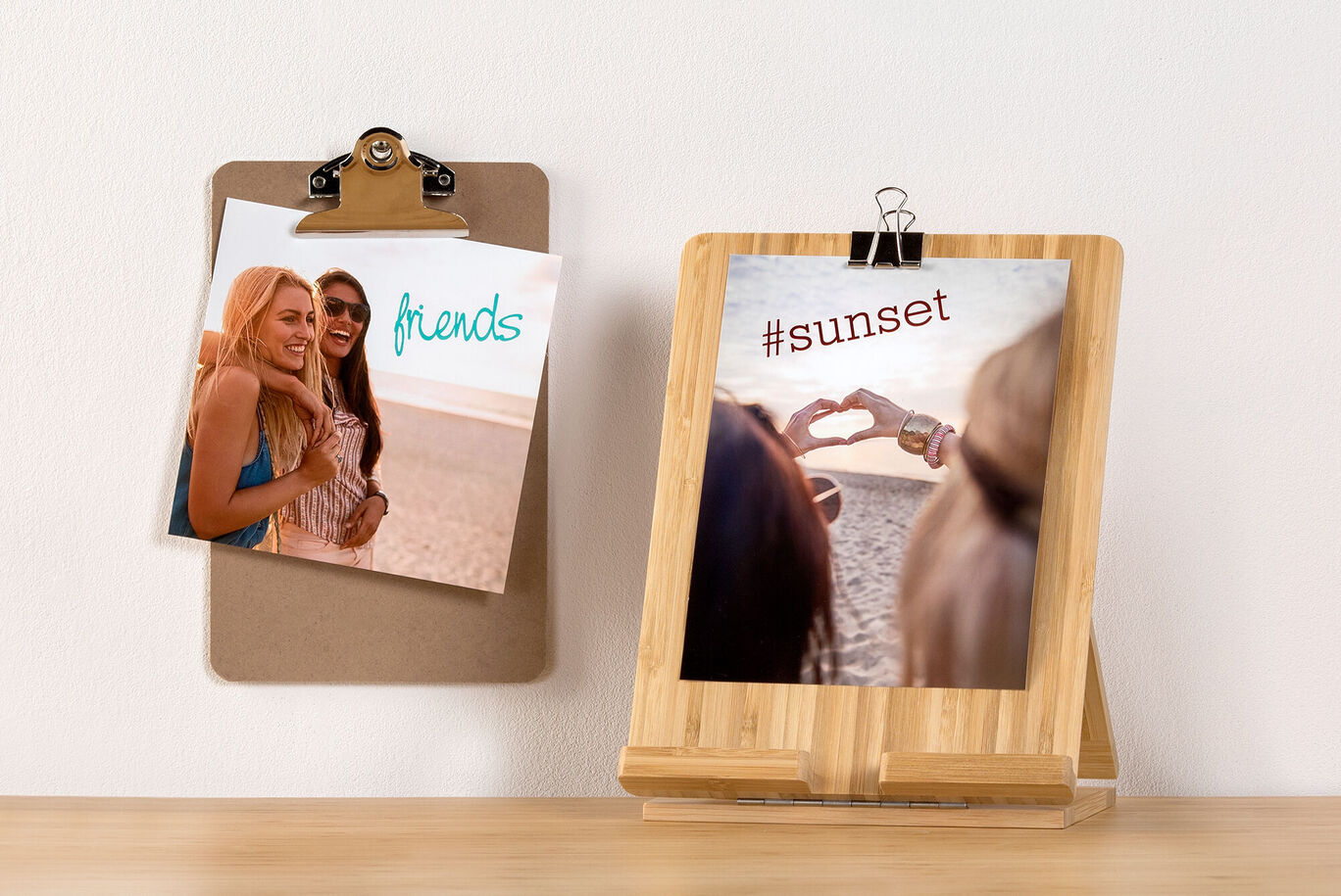 Dve fotky na drevenom stole, jedna s nápisom 'friends' a druhá '#sunset' s rukou v tvare srdca.