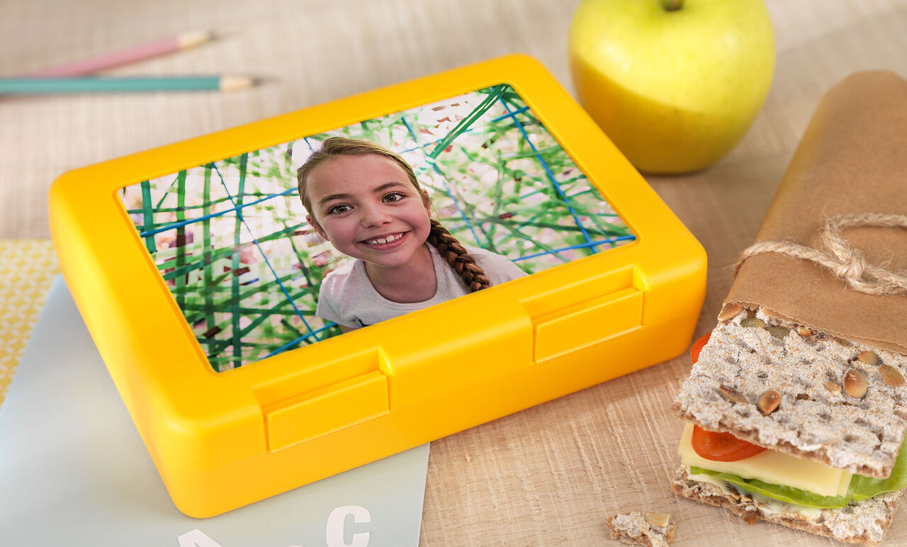 Farebná desiatová škatuľka na stole so zdravým sendvičom a jablkom
