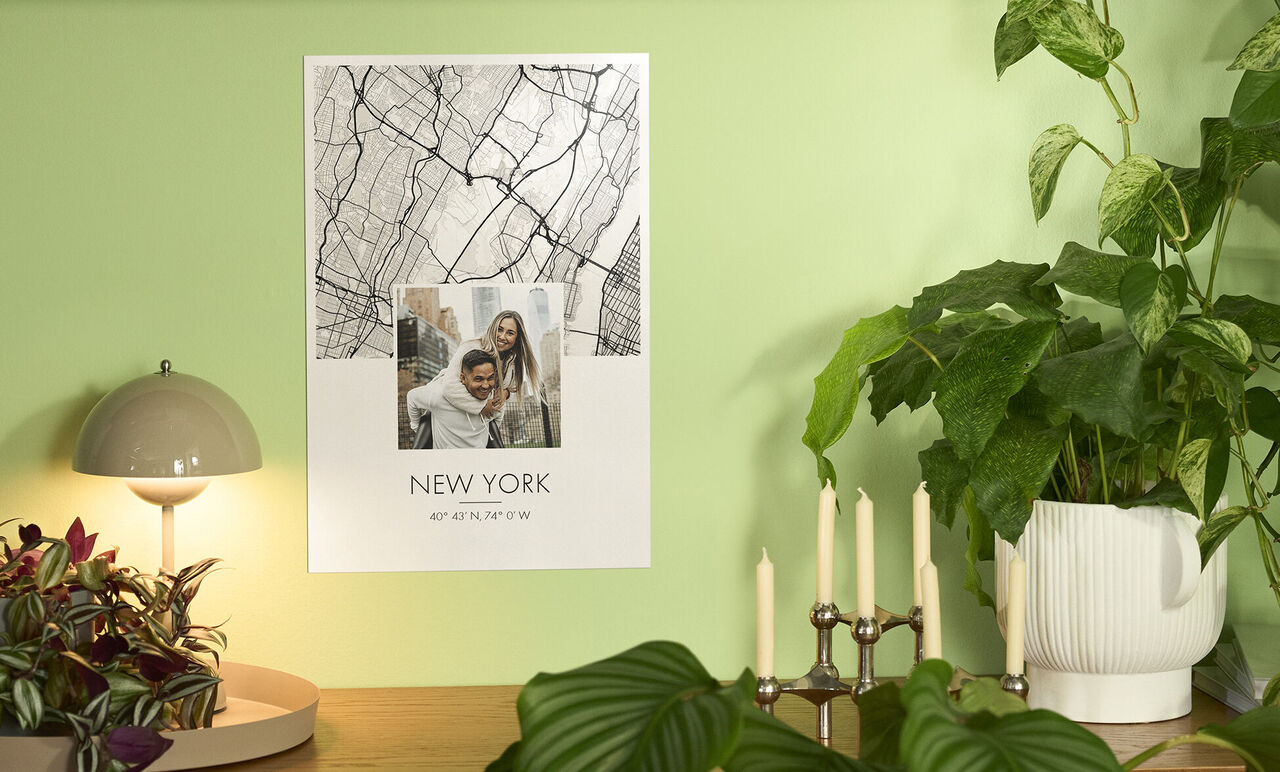 Poster New Yorku visí na zelenej stene. Obsahuje scénickú fotku a nápis "NEW YORK".