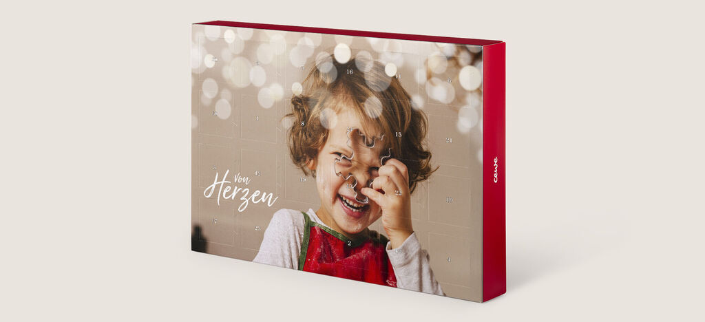 Krásne navrhnutá CEWE fotokniha so sviatočným obalom a jemnými svetlami.